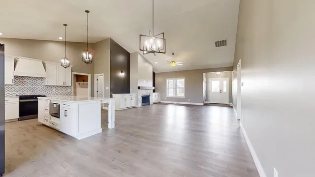 a view of a kitchen with a sink and dishwasher a fireplace with wooden floor