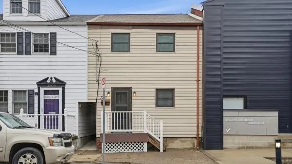 a view of a house with a door and a car parked in front of it