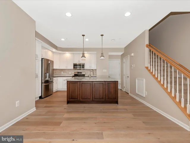 a kitchen with a stove and a wooden floor