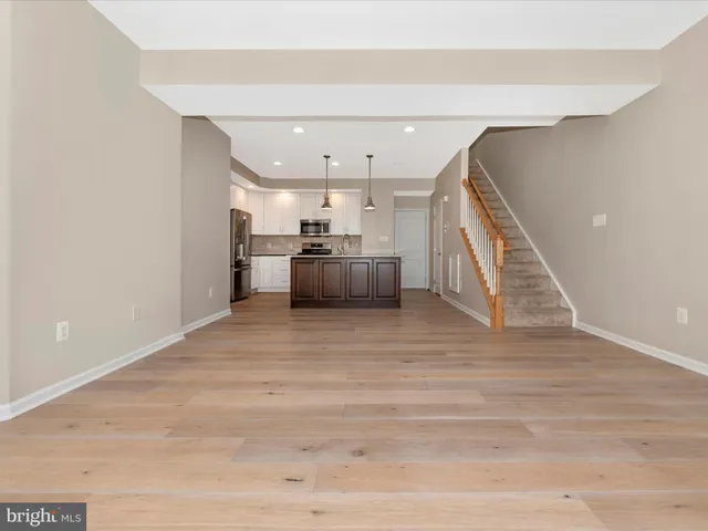 a kitchen with a refrigerator and a wooden floor