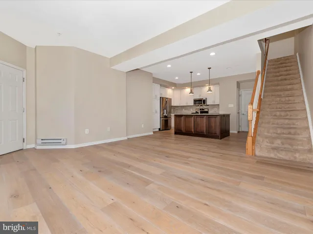 a kitchen with kitchen island granite countertop wooden cabinets a refrigerator a sink and a stove