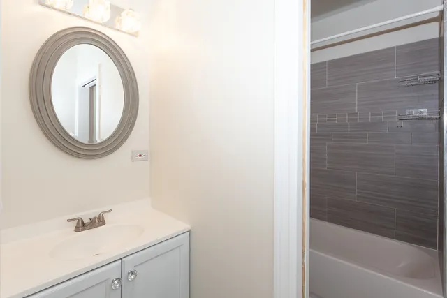 a bathroom with a sink a vanity and a bathtub