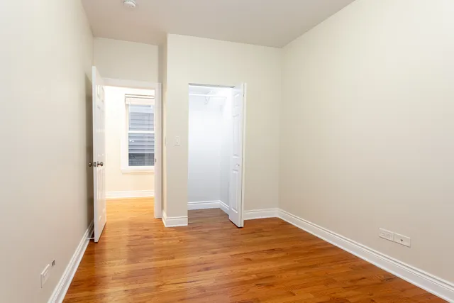 a view of empty room with wooden floor