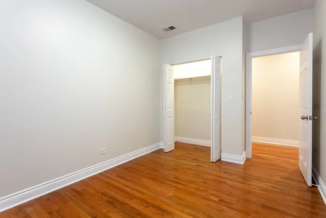 an empty room with wooden floor and closet
