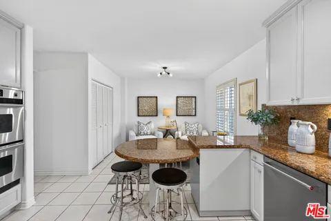 a kitchen with granite countertop a sink and white cabinets