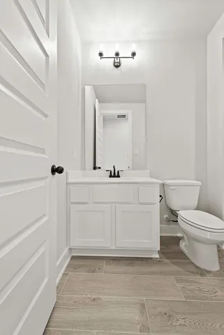 a bathroom with a sink vanity mirror and toilet