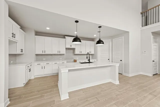a large kitchen with kitchen island a sink stainless steel appliances and cabinets