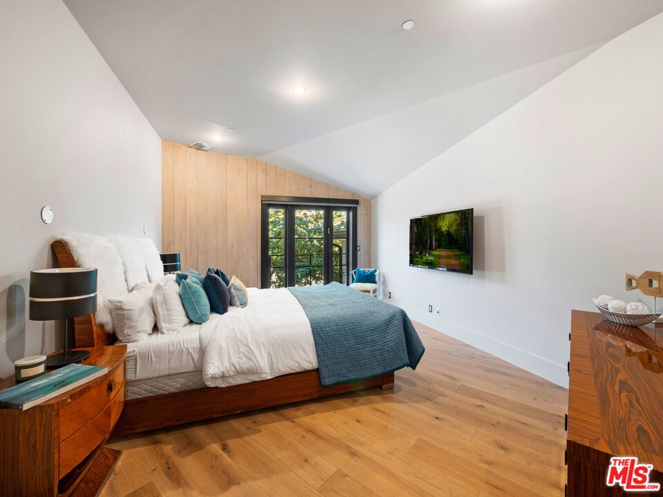 5207 Round Meadow Road Hidden Hills, CA 91302 - Photo 22 of 50 a bedroom with a bed a flat screen tv and a couch