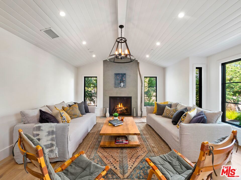 5207 Round Meadow Road Hidden Hills, CA 91302 - Photo 4 of 50 a living room with furniture a fireplace and a chandelier