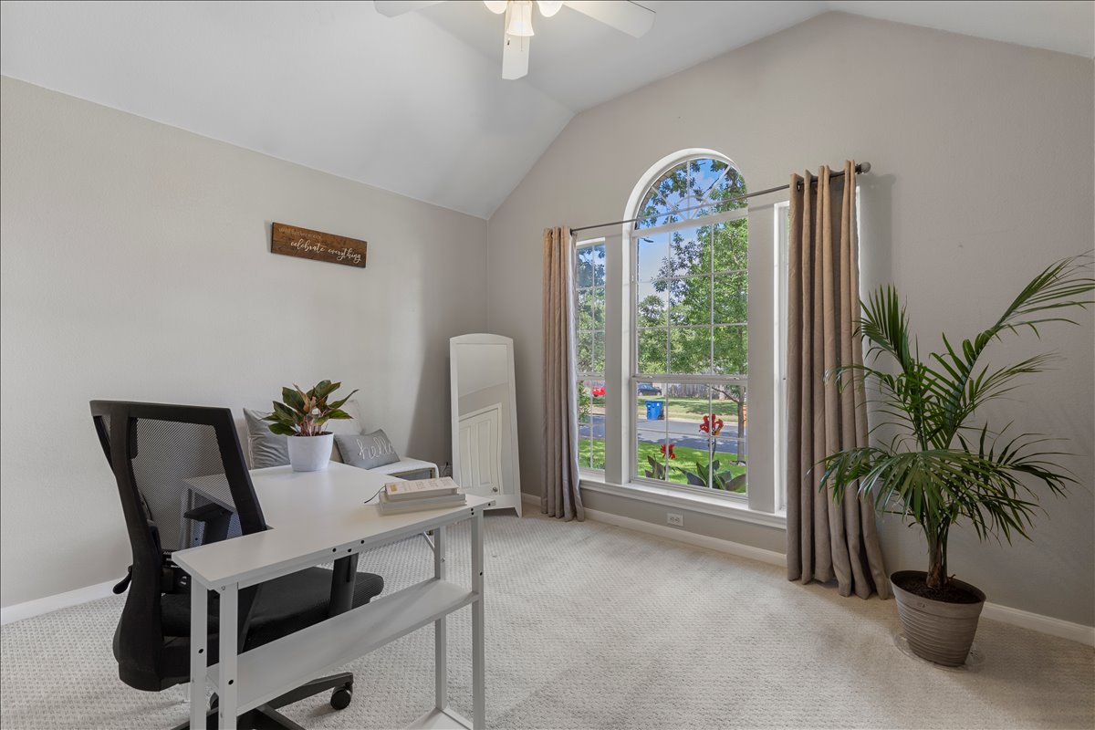 9012 Meacham Way Austin, TX 78749 - Photo 22 of 34 Spacious room featuring vaulted ceilings, a prominent arched window, and soft carpeting