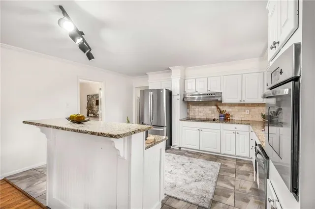 a kitchen with stainless steel appliances granite countertop a sink stove and refrigerator
