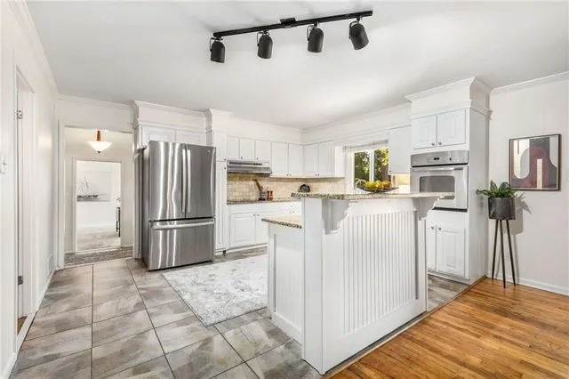 a kitchen with white cabinets and stainless steel appliances