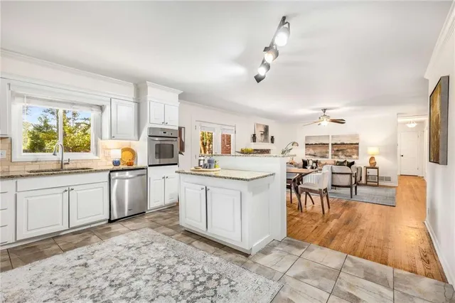 a kitchen with white cabinets and sink