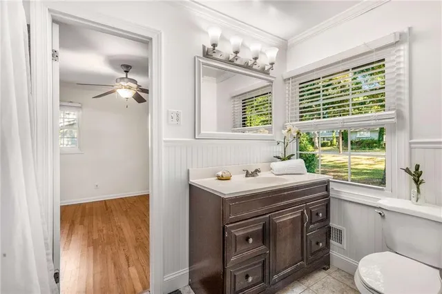 a bathroom with a sink a toilet and a window