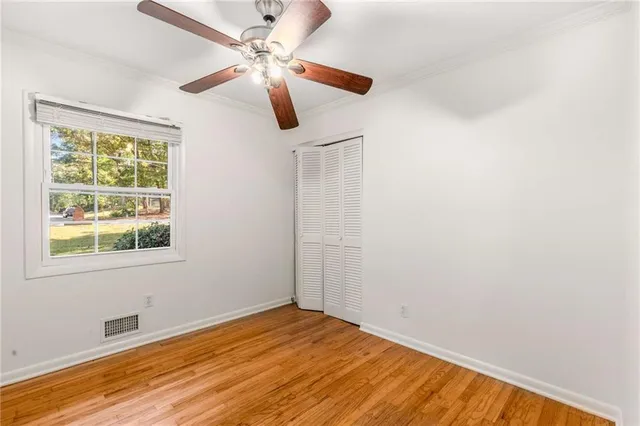 an empty room with a window and a ceiling fan