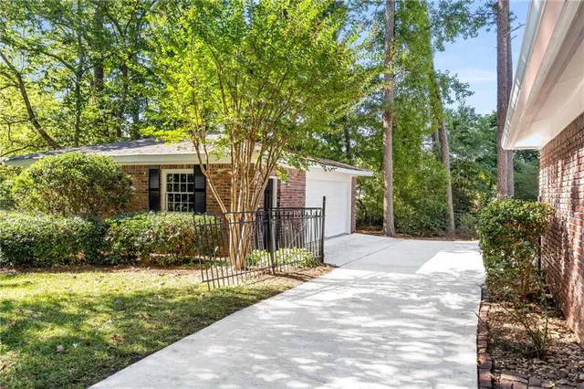 a front view of a house with a yard and tree