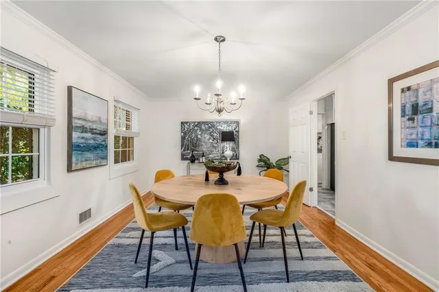 a dining room with furniture a chandelier and wooden floor