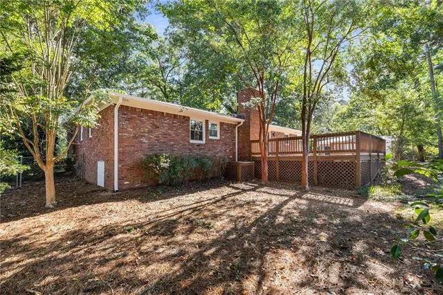 a backyard of a house with barbeque oven and trees