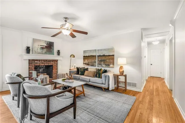 a living room with furniture a fireplace and a ceiling fan