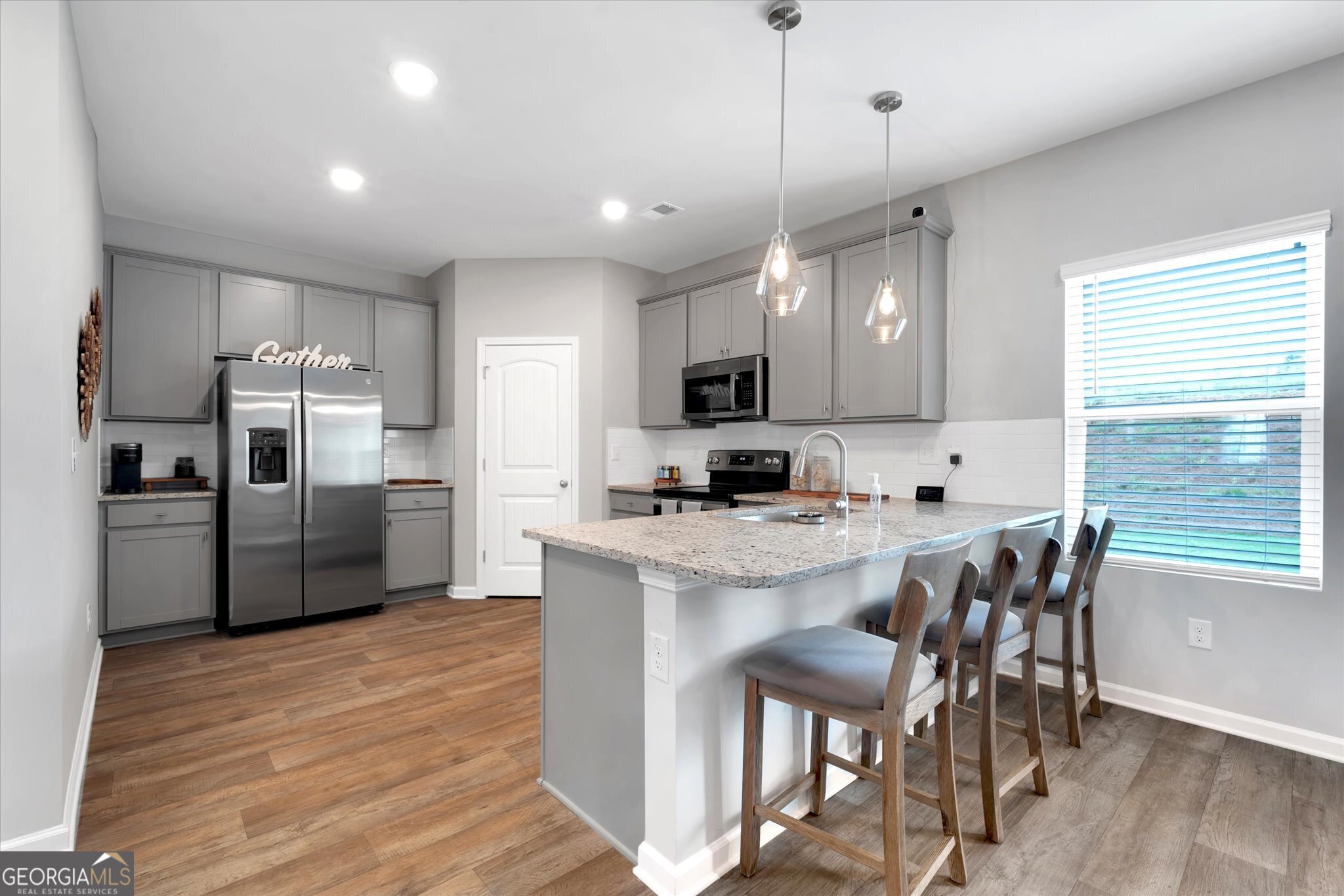 250 Rusty Plow Lane, Unit 25 Perry, GA 31069 - Photo 10 of 25 a kitchen with stainless steel appliances a microwave a stove a sink a refrigerator and chairs