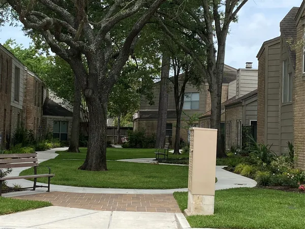 a front view of a house with a yard and large trees