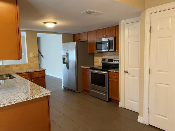 a kitchen with stainless steel appliances granite countertop a refrigerator and a stove