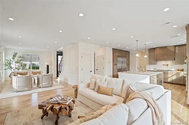 a living room with furniture and a dining table with kitchen view