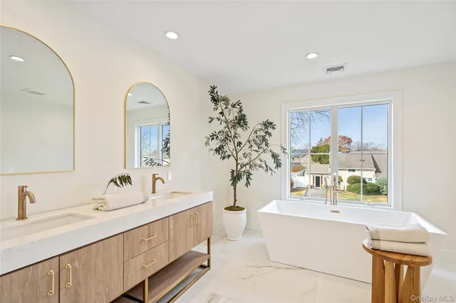 a bedroom with a bed and a large mirror with a dresser