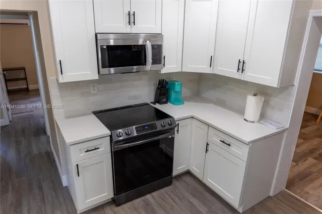 a kitchen with white cabinets and white appliances
