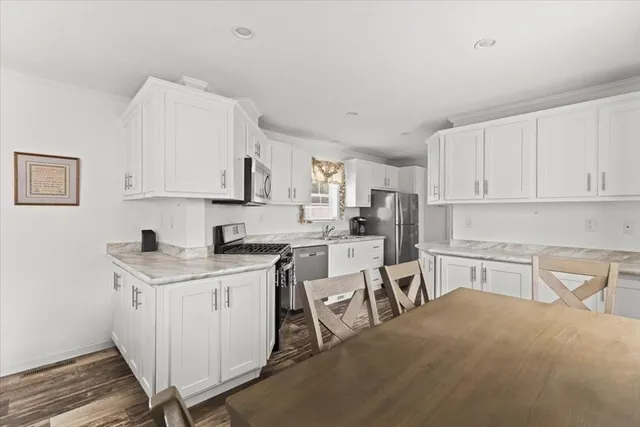 a kitchen with a sink stove top oven and white cabinets