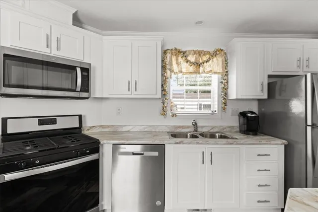 a kitchen with granite countertop cabinets stainless steel appliances and a window