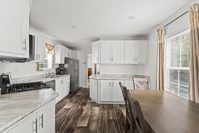 a kitchen with a refrigerator a sink and white cabinets