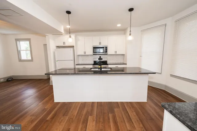 a view of kitchen with microwave and wooden floor