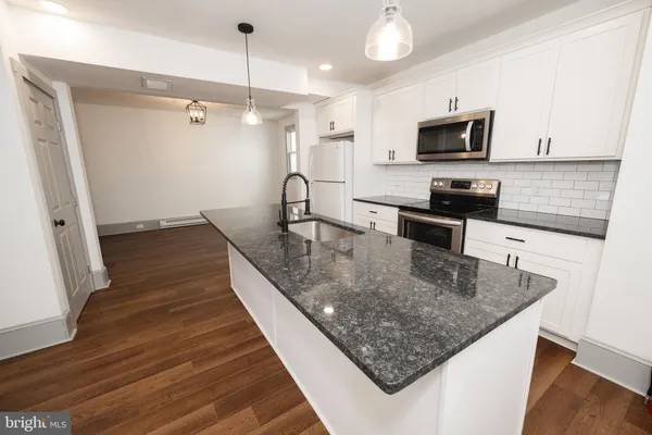 a kitchen with stainless steel appliances granite countertop a sink a microwave counter space and cabinets