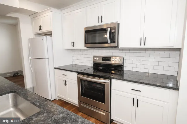 a kitchen with stainless steel appliances granite countertop a stove microwave and refrigerator