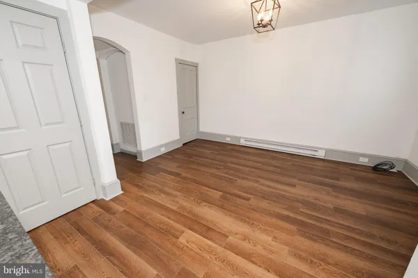 a view of a room with wooden floor and white wall