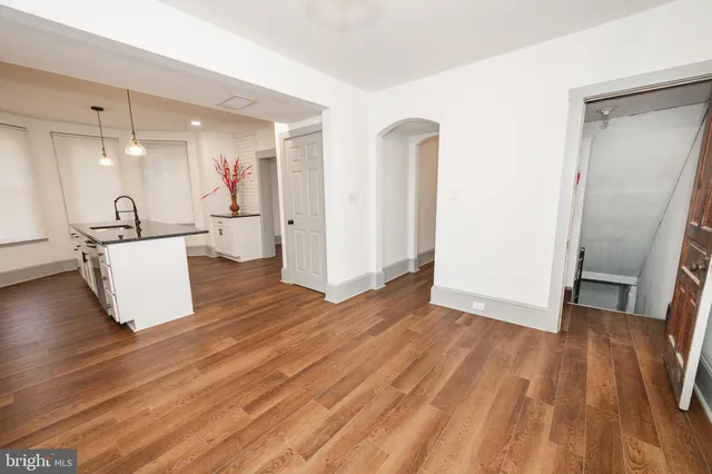 a view of a room with wooden floor and a refrigerator