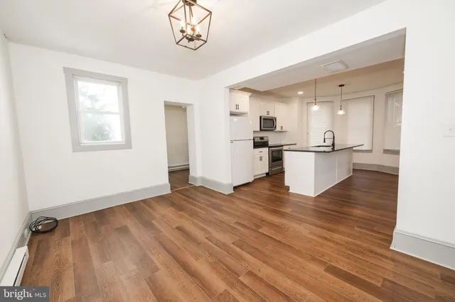 a view of a kitchen with a sink and wooden floor