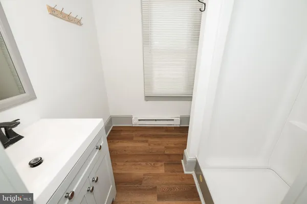 a bathroom with a tub sink and mirror