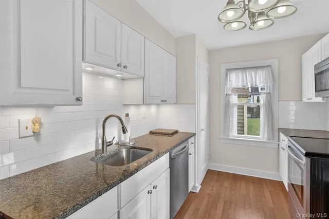 a kitchen with stainless steel appliances granite countertop a sink a stove a refrigerator and cabinets