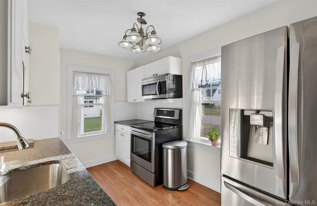 a kitchen with stainless steel appliances granite countertop a refrigerator stove and sink