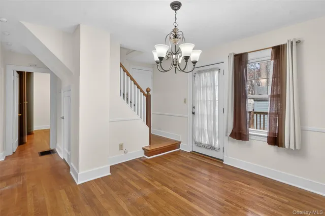 a view of a livingroom with wooden floor and stairs