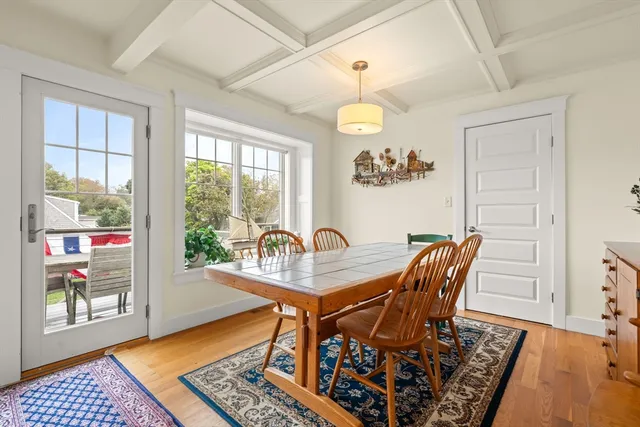 a dining room with furniture wooden floor a rug and a chandelier