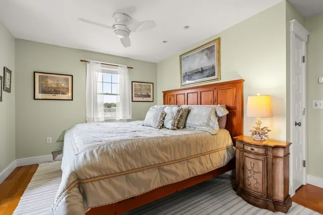 a bedroom with a bed a window and painting on the wall