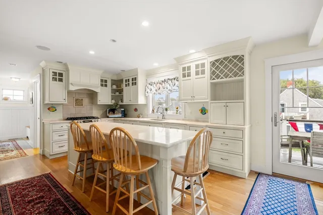 a living room with furniture a rug and kitchen view