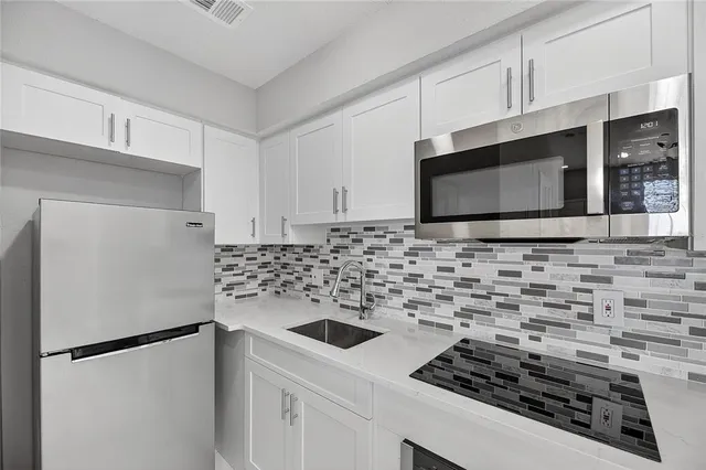 a kitchen with a stove a refrigerator and cabinets