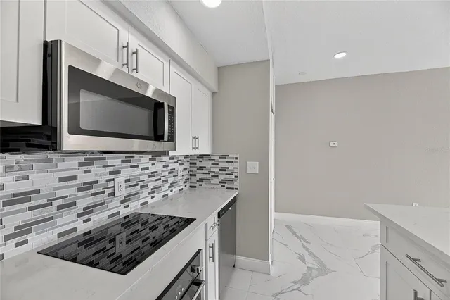 a kitchen with stainless steel appliances a stove a microwave and a sink