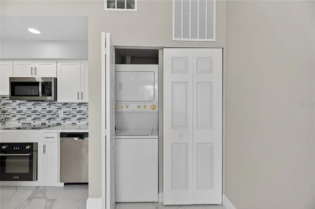 a kitchen with white cabinets and stainless steel appliances