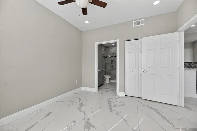 an empty room with fan and entrance door