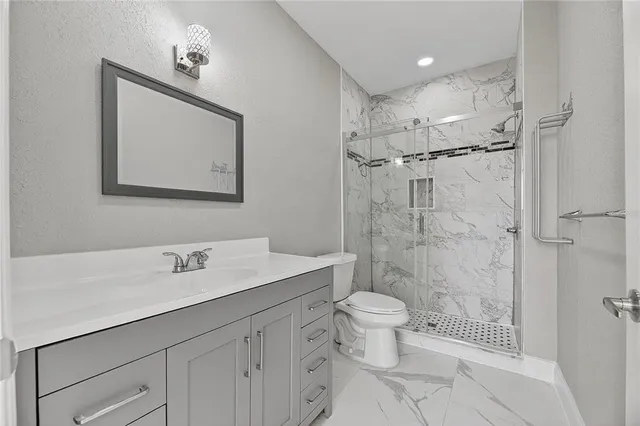 a bathroom with a sink a toilet and shower